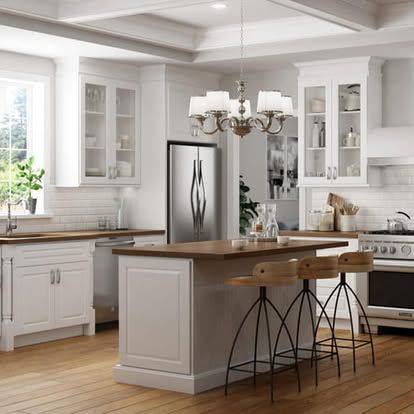A very high end kitchen with island and bar stools.