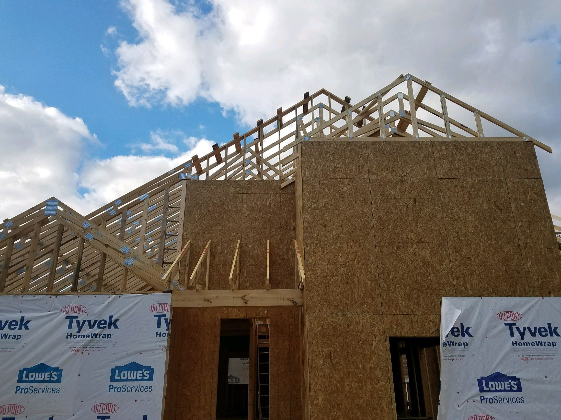 Roof trusses set above sheathed second-story walls.