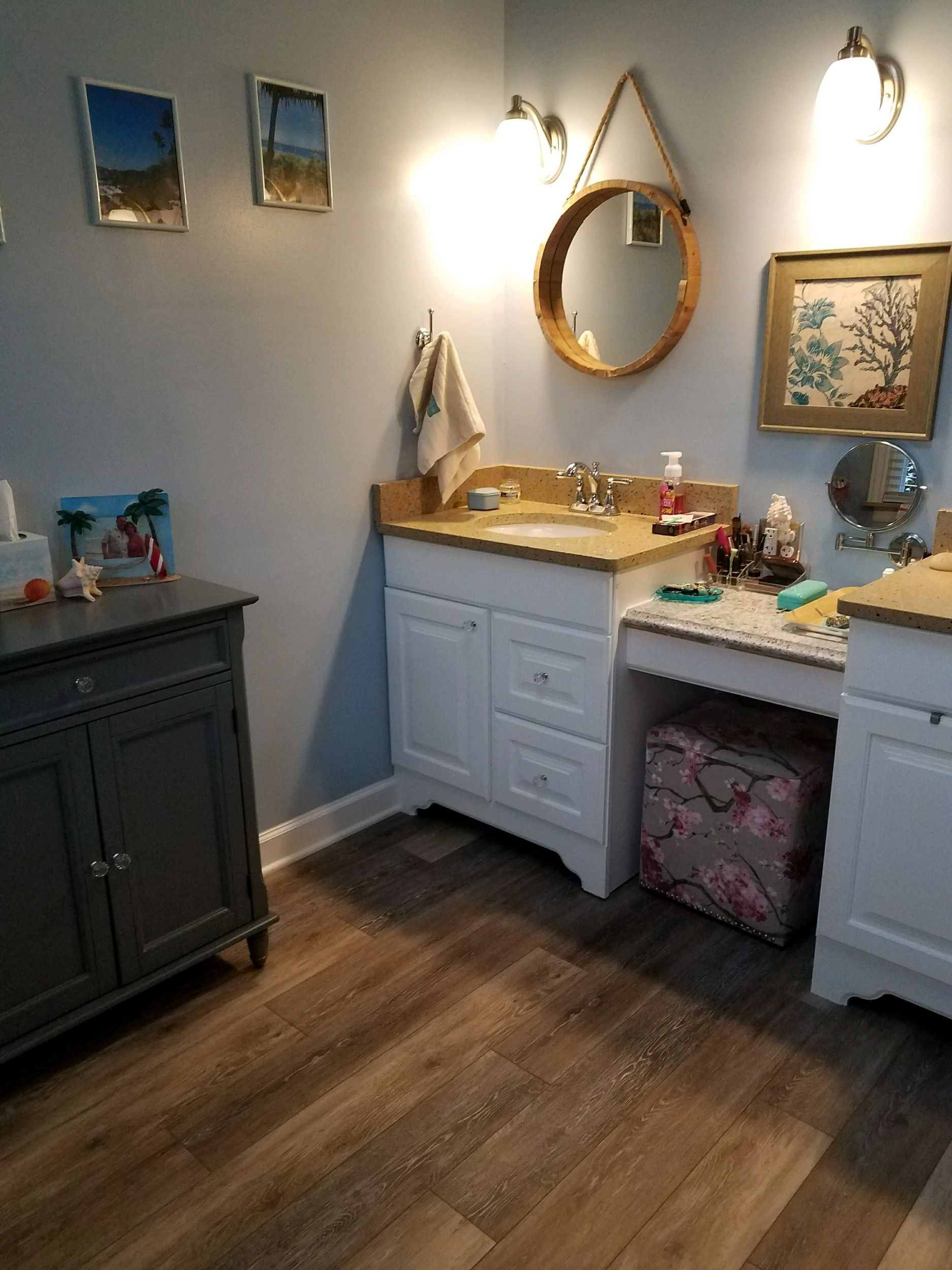 White vanity with a lowered makeup counter and round mirror.